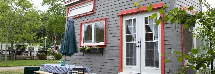 Graues Tiny House mit roter Verkleidung